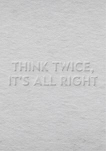 Das Bild zeigt einen strukturierten, hellgrauen Hintergrund mit einem eingeprägten Text: "THINK TWICE, IT'S ALL RIGHT". Der Text ist subtil und wirkt fast als Teil der Oberfläche, was ihm ein minimalistisches und elegantes Aussehen verleiht.